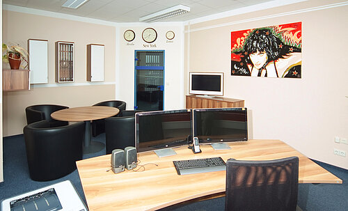 Büro mit großen Schreibtisch, Sitzecke und Ausrüstung