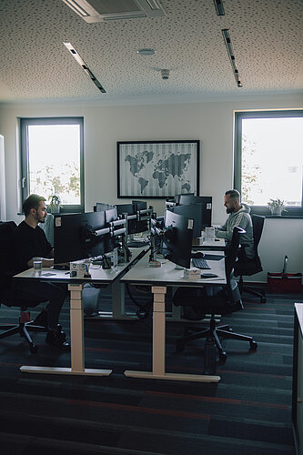 modern office room with two men sitting at their desks