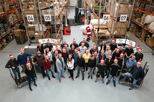 Team picture of all Cybertrading GmbH employees in the warehouse