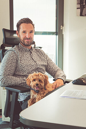 CEO Frank Niemann with dog Chewy at his desk