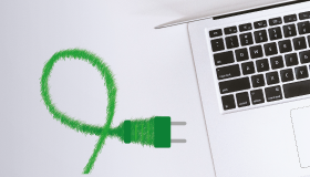 Green power cord with plug next to a notebook