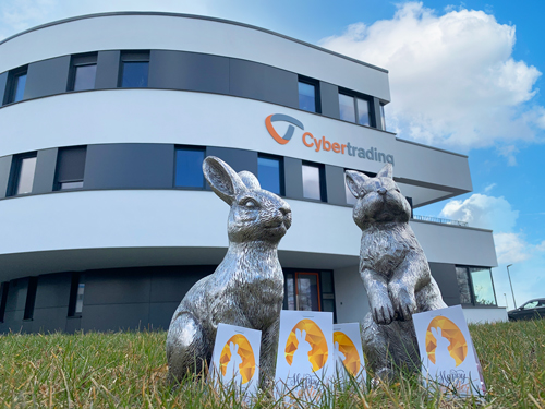Cyber bunnies with Easter eggs in front of the company building