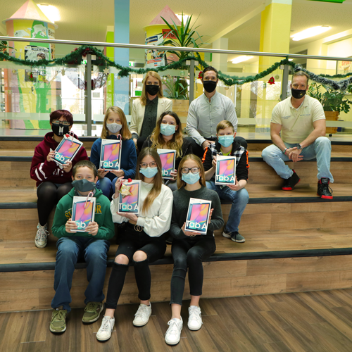 Children with tablets handing over donations