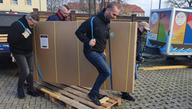Helpers carry the donation - floorball set and billiard table to the club