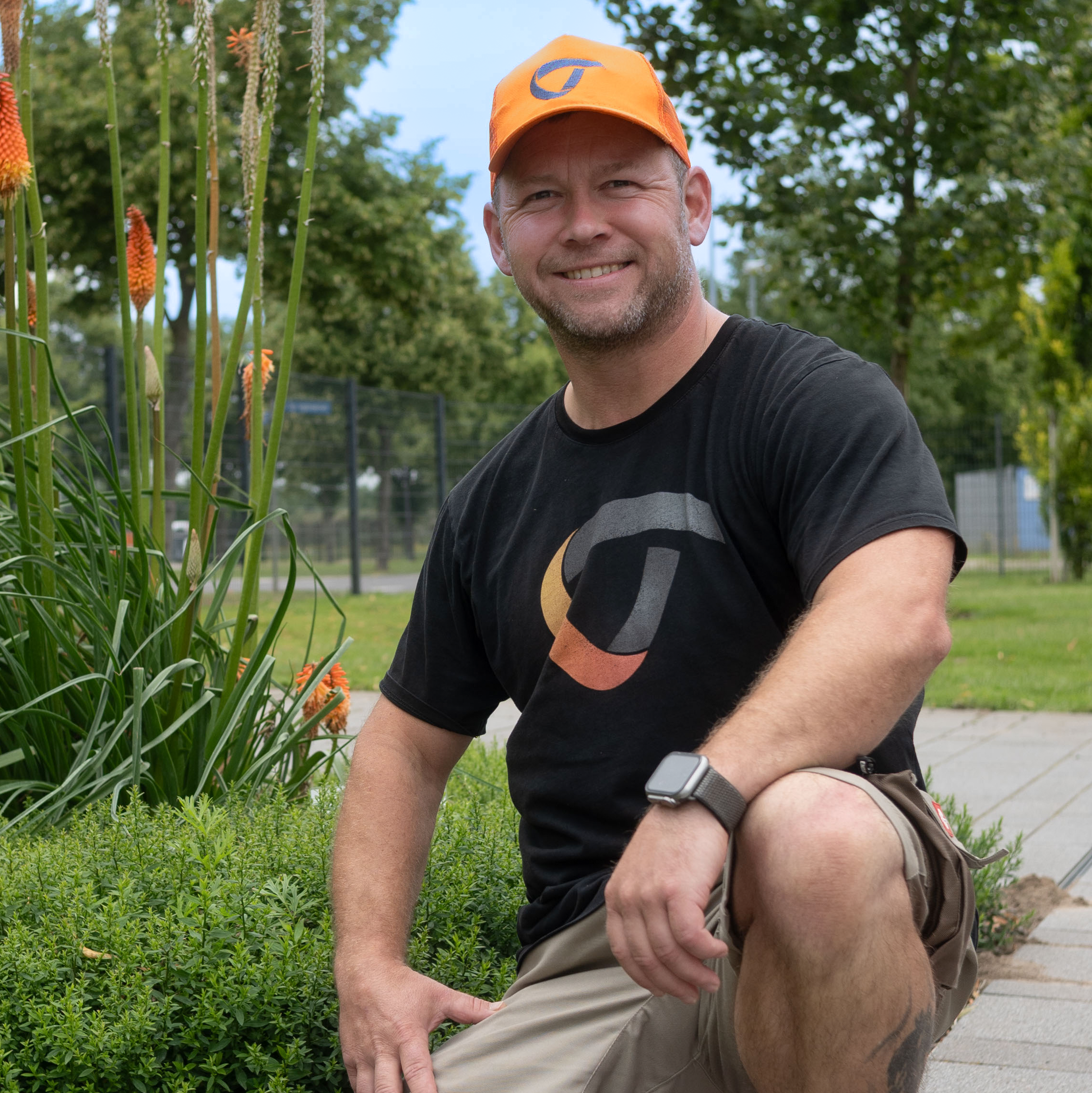 Employee crouching in front of a meadow