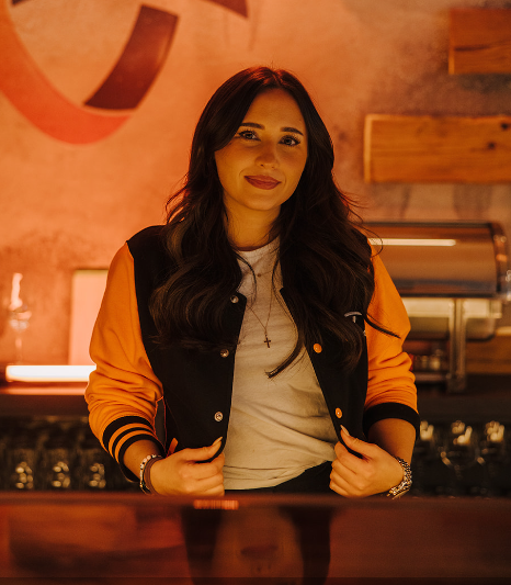 Employee standing at the counter with her hands in her pockets