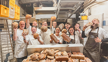 Mitarbeiter mit Brot in der Bäckerei